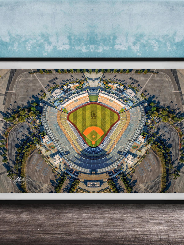 The image is an aerial view of a baseball stadium, featuring a large field surrounded by parking lots and other structures.