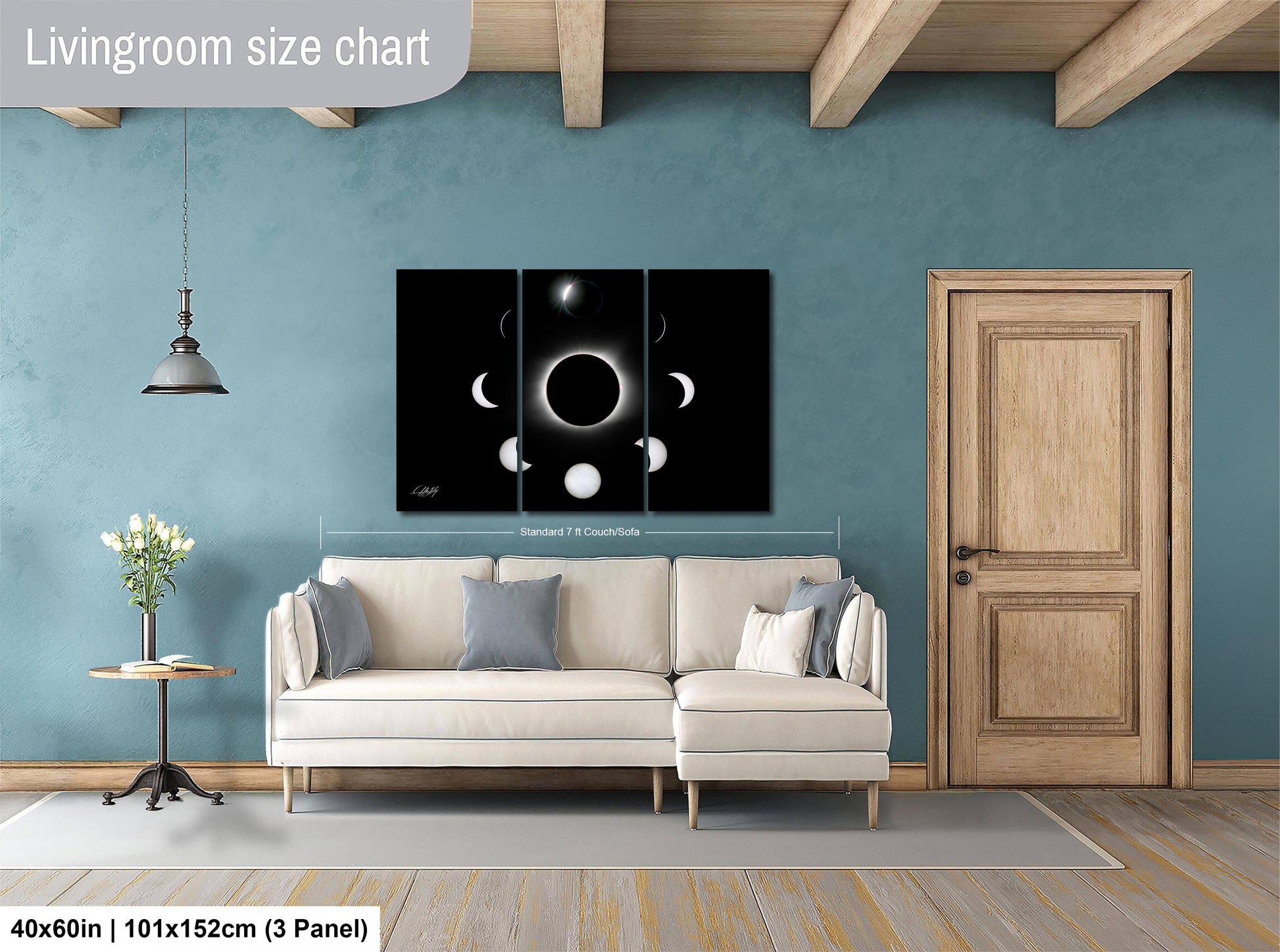 The image is a living room with a white sofa, a wooden door, and a large black and white solar eclipse artwork on the wall.