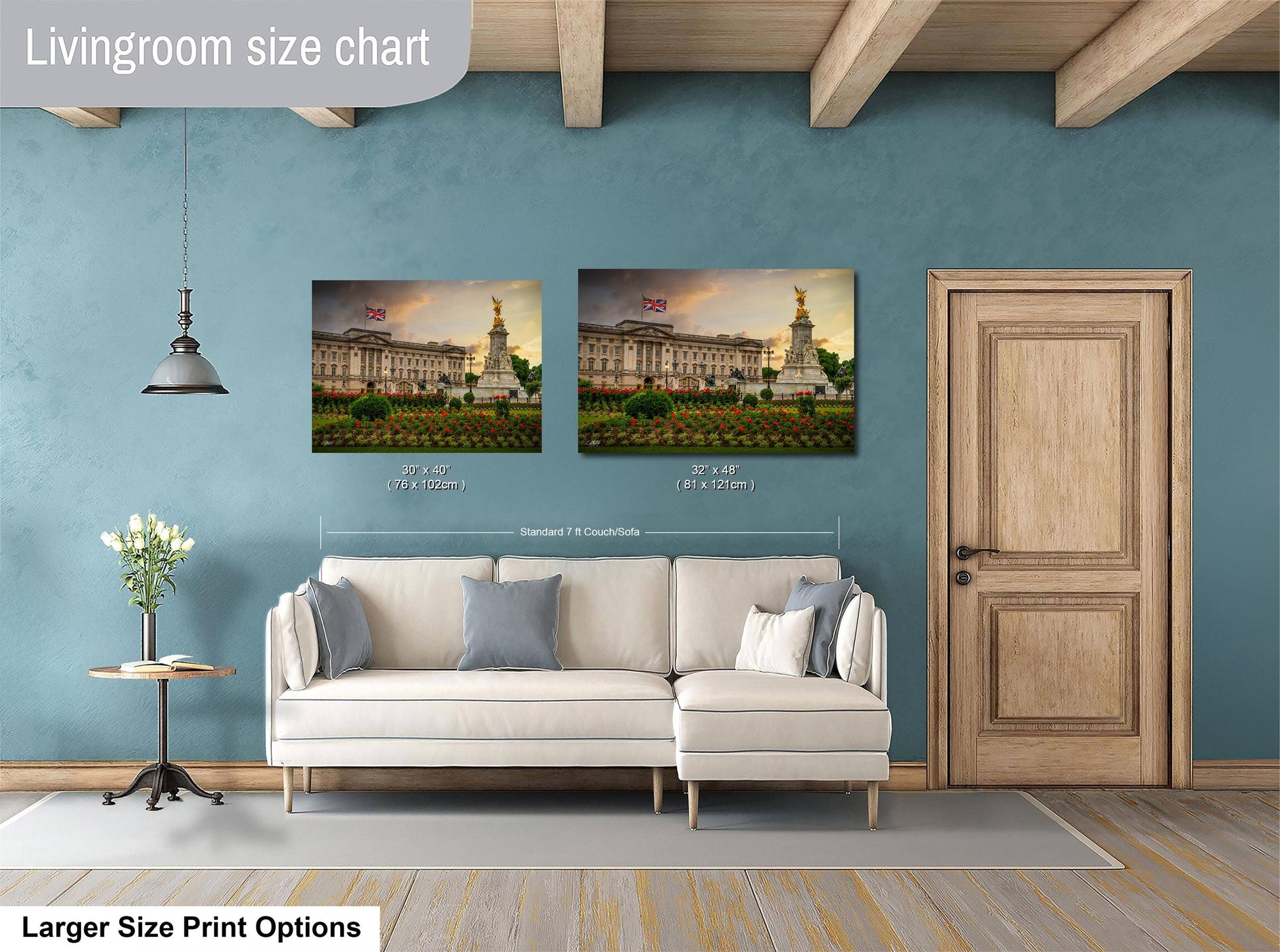 a living room with a white sofa and a wooden door. Above the sofa, there are two framed pictures of a building, likely a palace, with a British flag displayed. The living room has a blue wall and a wooden ceiling.