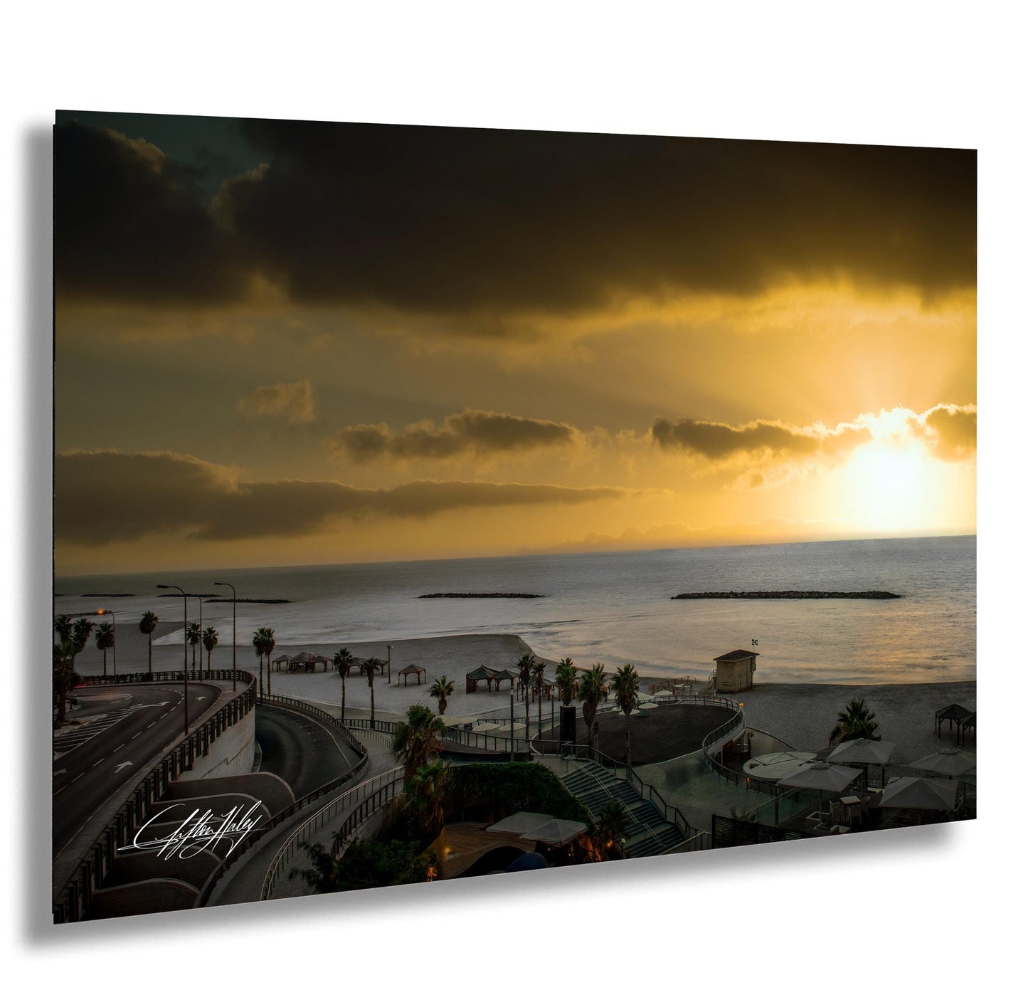 a serene beach scene at sunset, with palm trees lining the shore and a large body of water in the background.