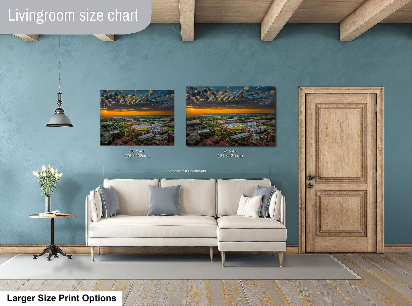a living room with a white sofa and a wooden door. Above the sofa, there are two framed pictures of a cityscape, with one picture being larger than the other. The living room has a blue wall and a wooden ceiling.