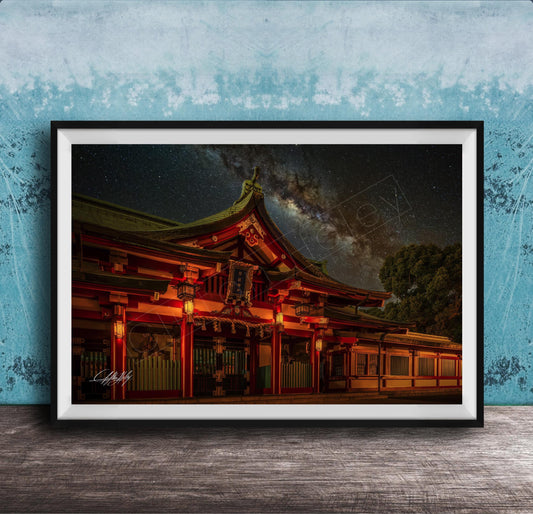 A framed photograph depicting a traditional Japanese temple at night, with a starry sky and a galaxy in the background.