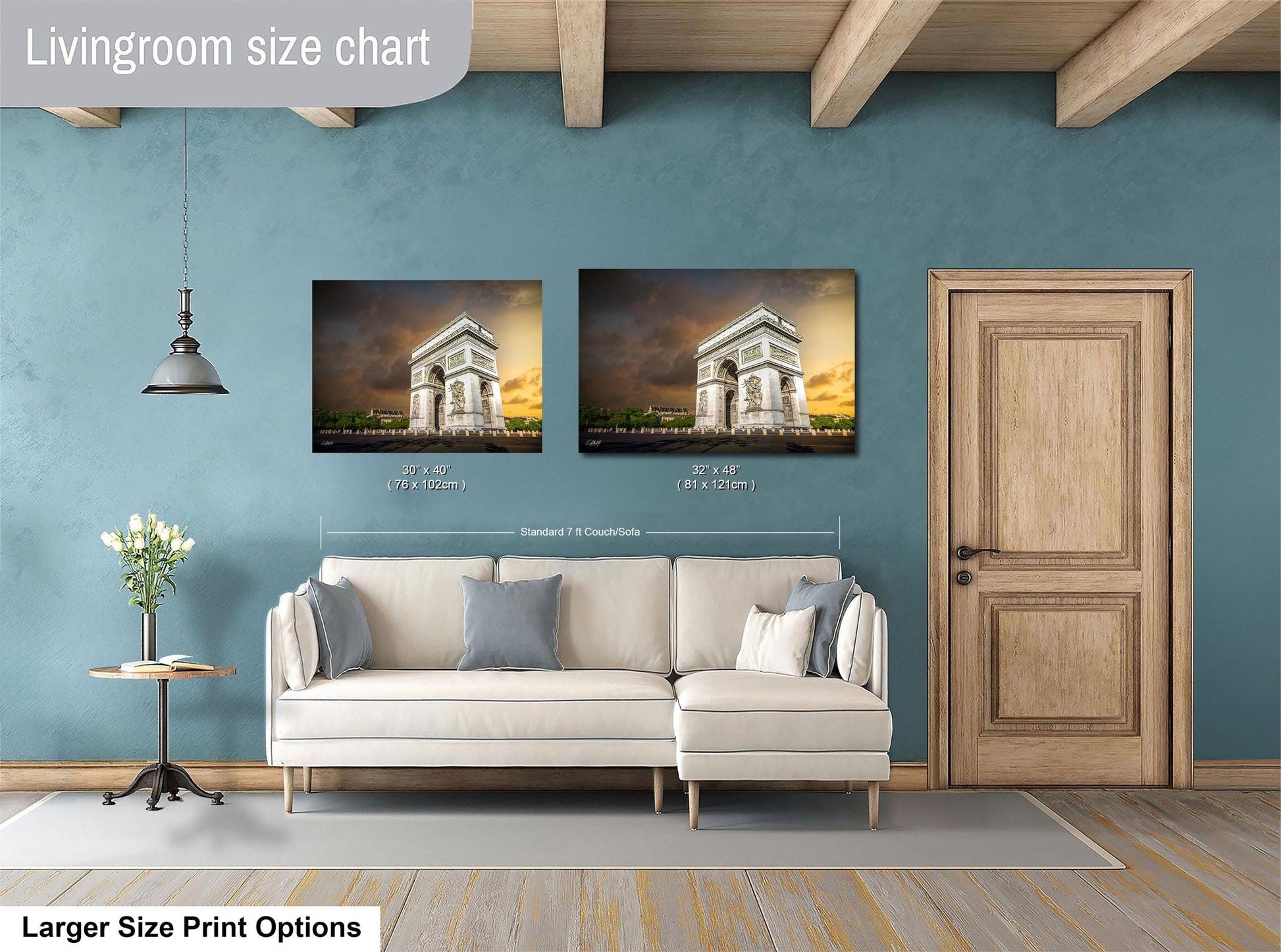 a living room with a white sofa, a wooden door, and a painting of the Arc de Triomphe on the wall.