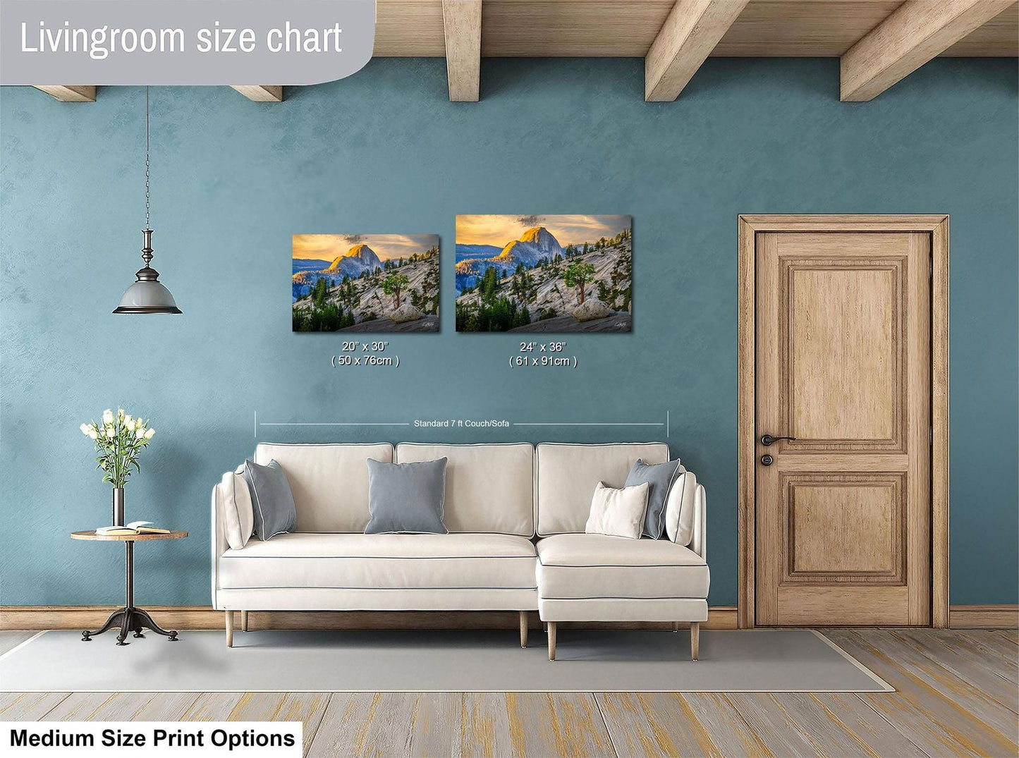 a living room with a white sofa, a wooden door, and a painting of a mountain landscape on the wall. The painting is of two different sizes, with one being larger than the other. The living room appears to be well-decorated and spacious.