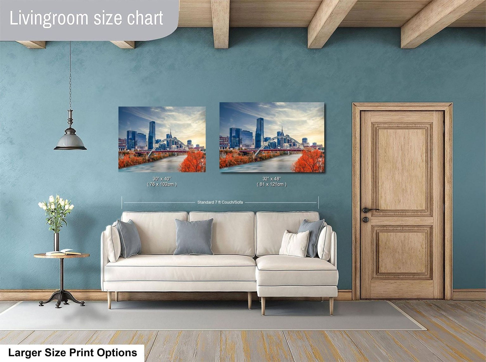 a living room with a white sofa and a wooden door. Above the sofa, there are two framed pictures of a city skyline, with one picture being larger than the other. The living room has a blue wall and a wooden ceiling.