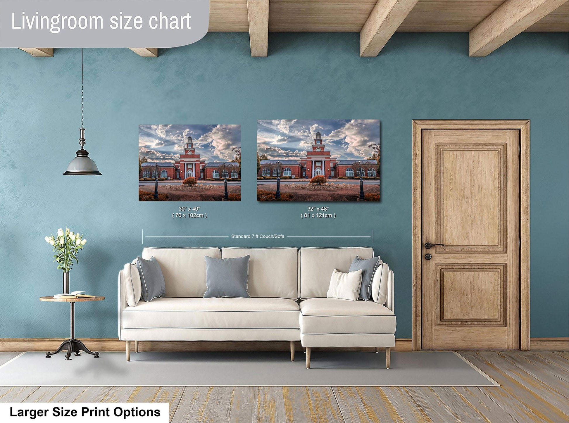 a living room with a white sofa and a wooden door. Above the sofa, there are two framed pictures of a building, likely a church, hanging on the wall. The living room has a blue wall and a wooden ceiling.