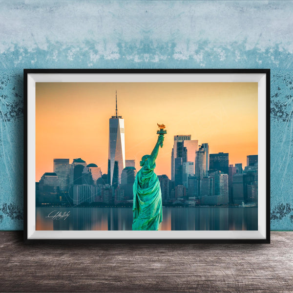 A framed photograph of the Statue of Liberty in New York City, with the city skyline in the background.