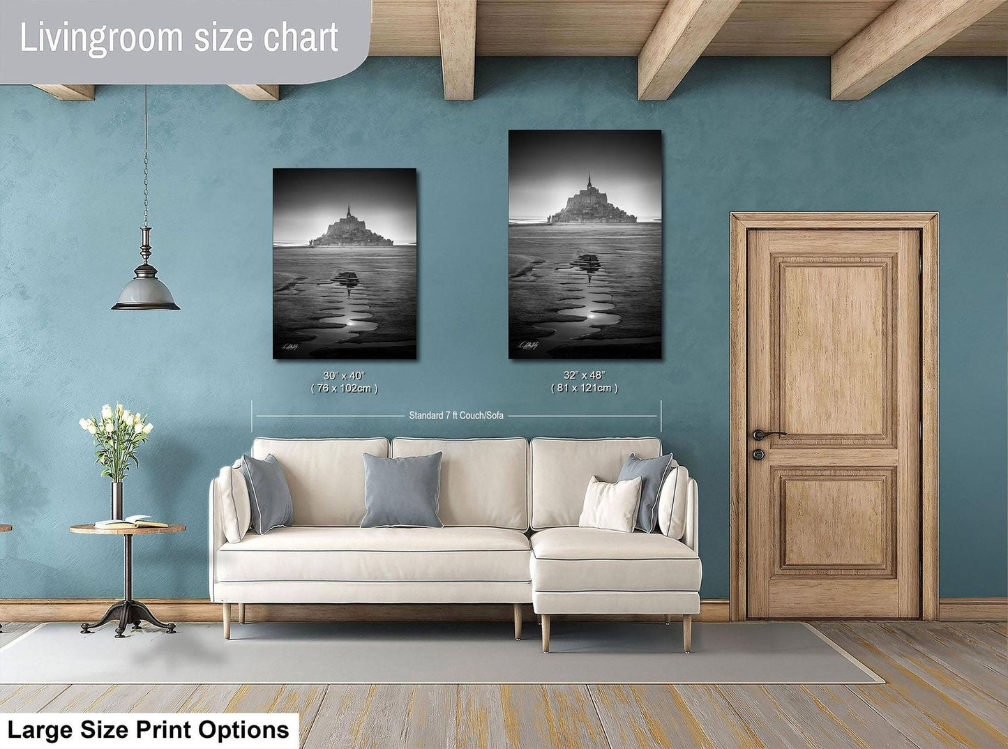 a living room with a white sofa, a wooden door, and two framed black and white photographs hanging on the wall.