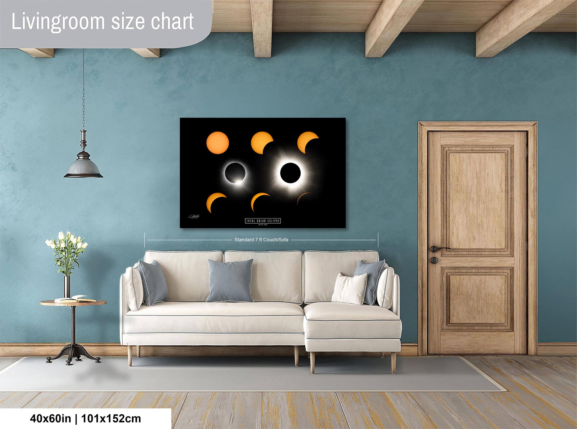 a living room with a white sofa, a wooden door, and a large black and white poster of the solar eclipse on the wall.