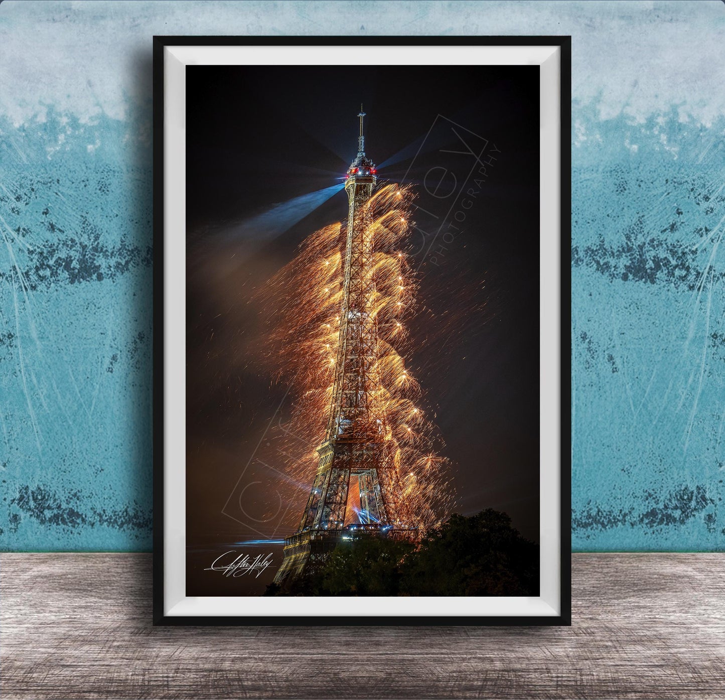 a tall, illuminated tower with a fireworks display lighting up the night sky.
