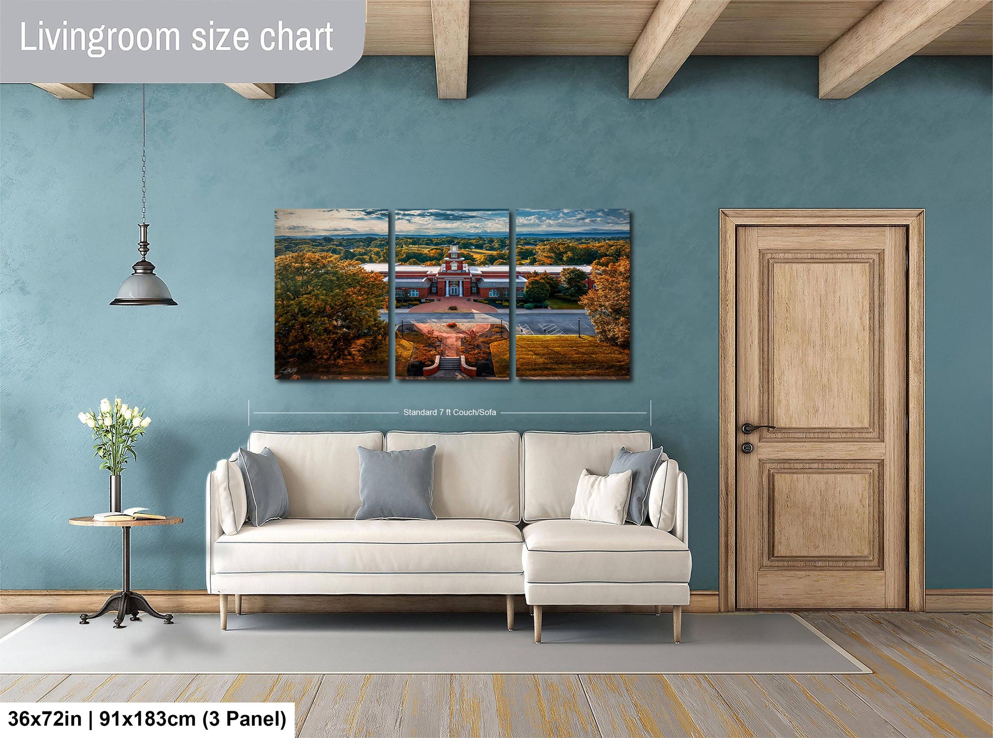 The image is a living room with a large white sofa and a wooden door. Above the sofa, there is a large living room size chart that provides dimensions for the artwork hanging on the wall.