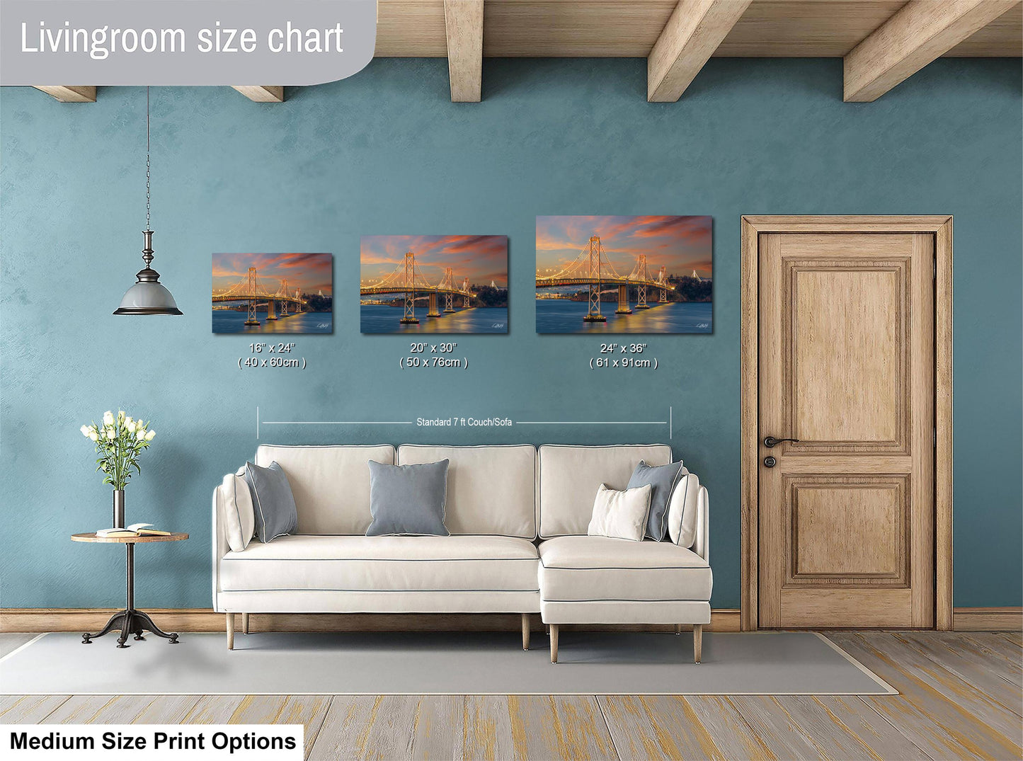a living room with a white sofa and a wooden door. Above the sofa, there is a livingroom size chart that provides the dimensions of three framed prints of a bridge at different sizes.