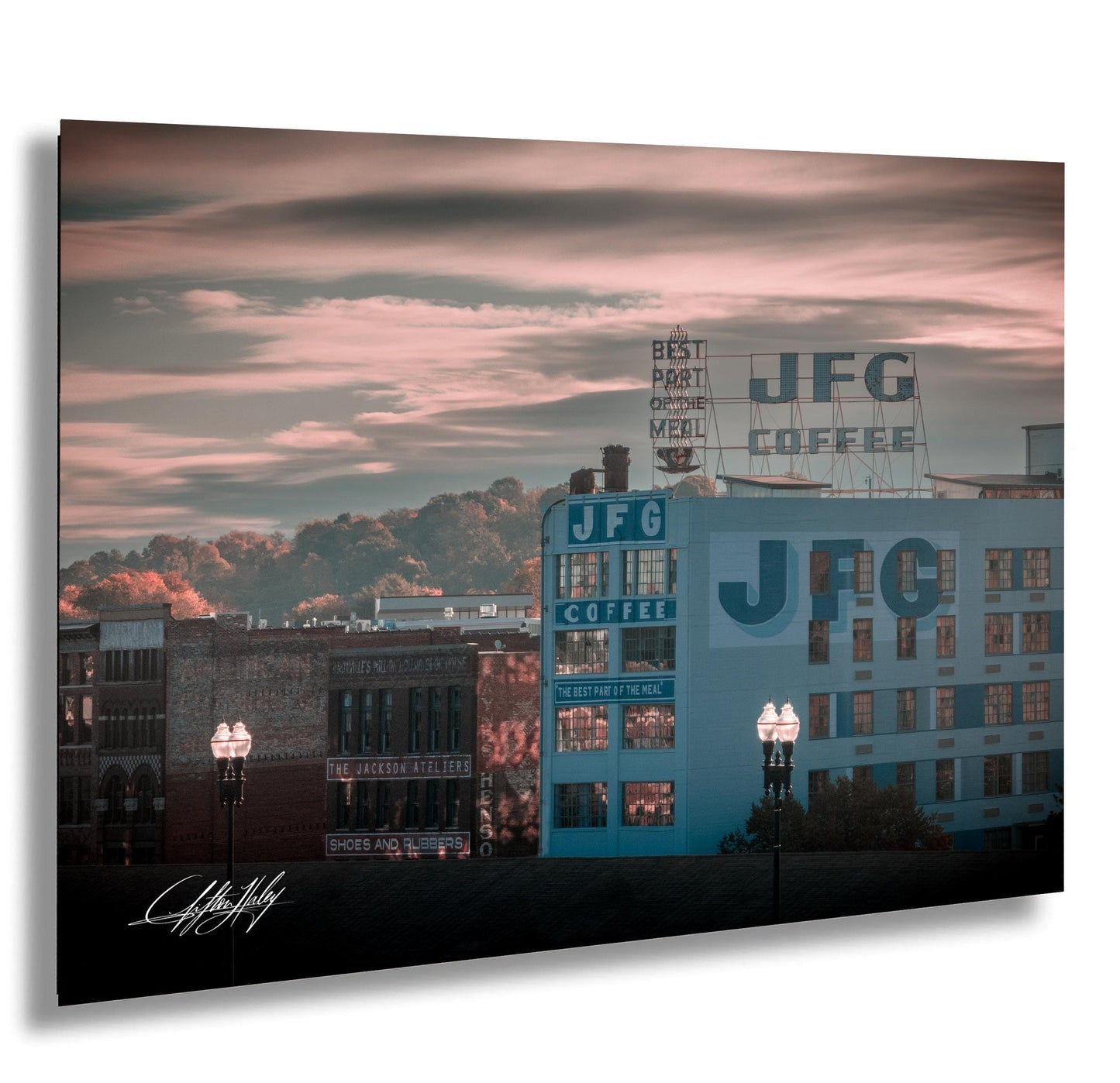 a cityscape with a large JFGC coffee advertisement on the side of a building, set against a colorful sky.