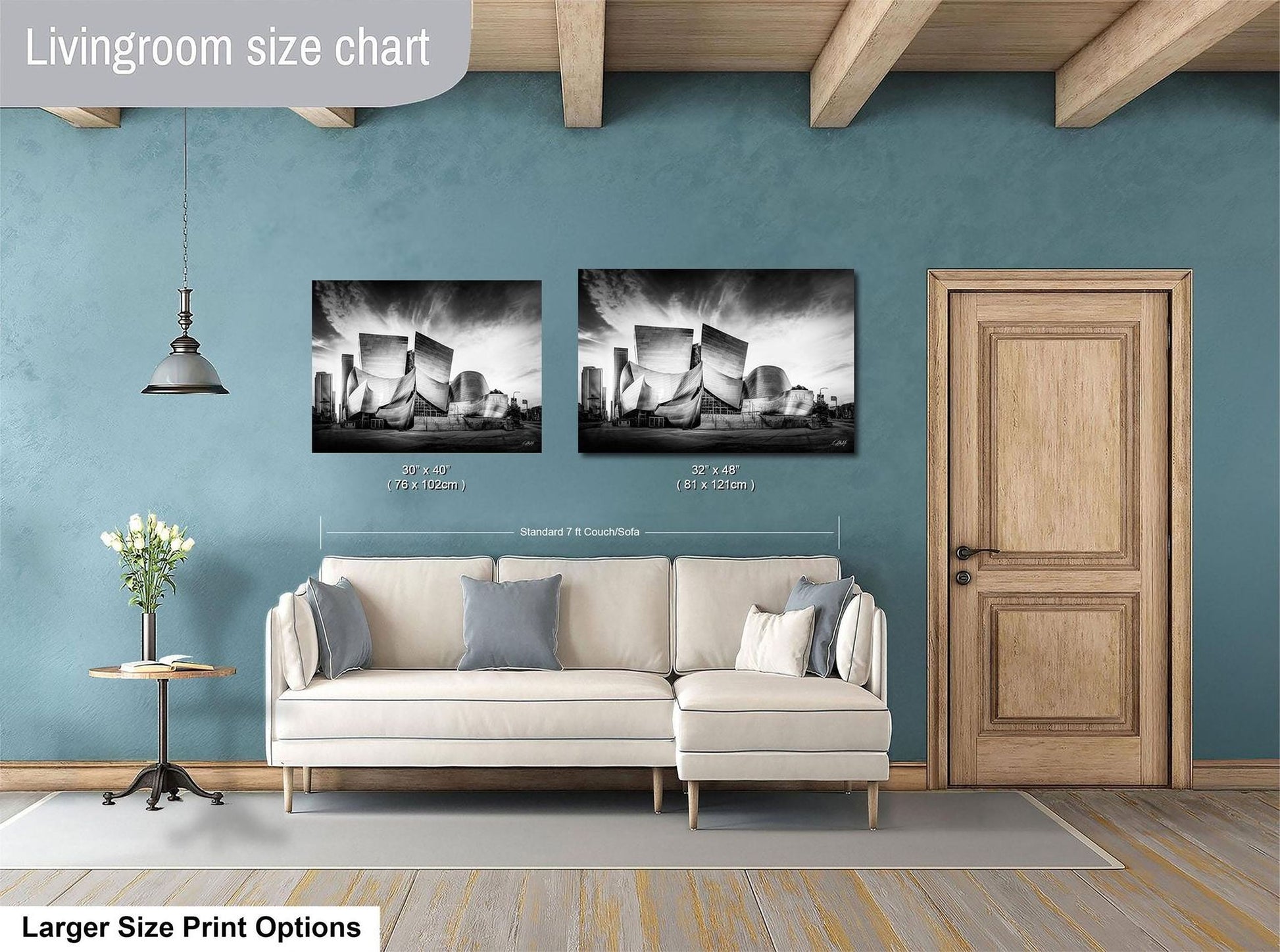 a living room with a white sofa, a wooden door, and two framed black and white photographs hanging on the wall.