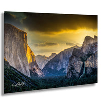 a breathtaking view of a mountainous landscape at sunset, with towering cliffs and a cascading waterfall.