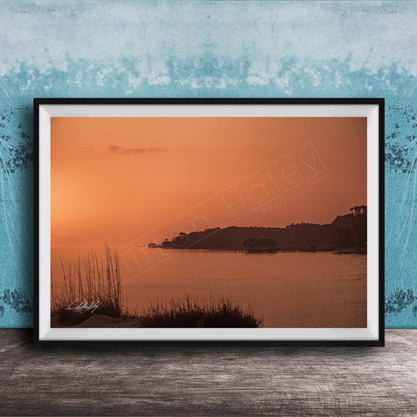 a serene sunset over a body of water, with a small island visible in the distance.