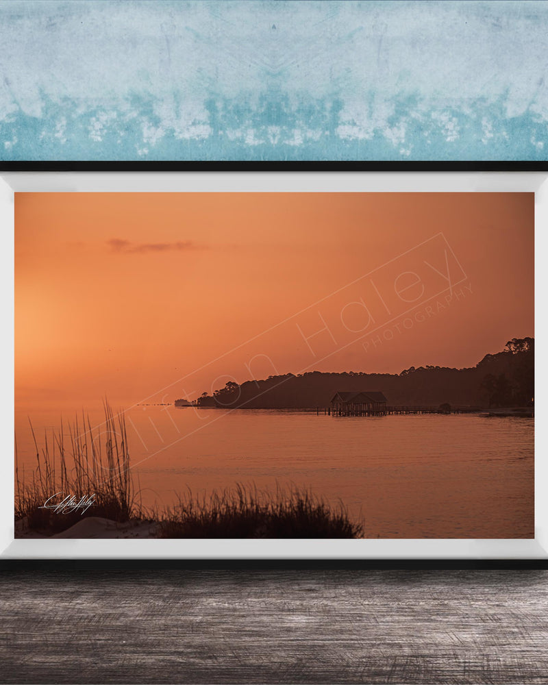 a serene sunset over a body of water, with a small island visible in the distance.