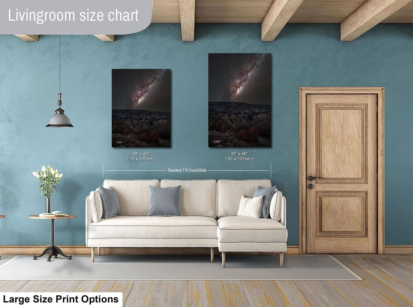 a living room with a white sofa, a wooden door, and two framed pictures of a galaxy hanging on the wall.