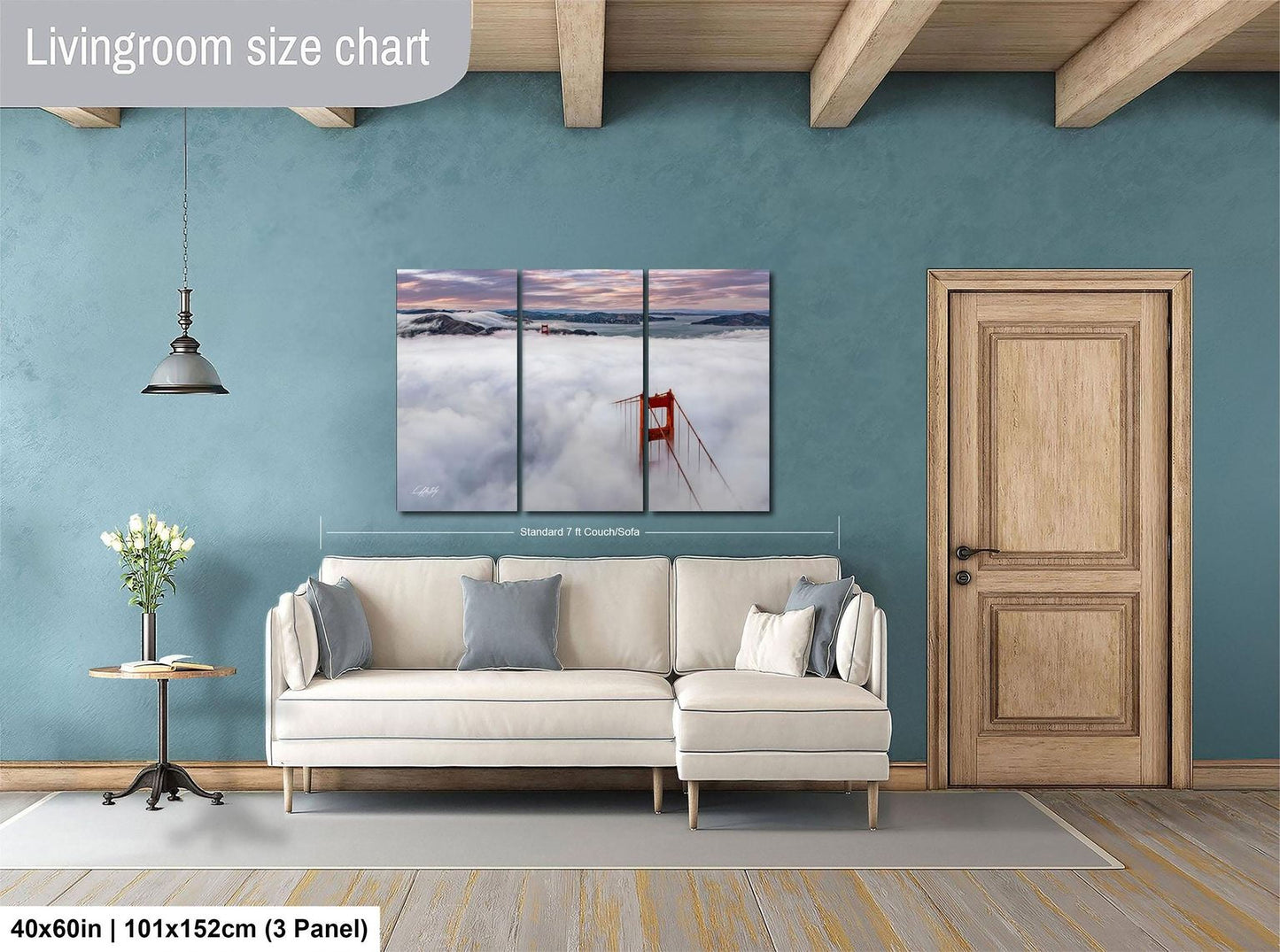The image is a living room with a large white sofa, a wooden door, and a painting of the Golden Gate Bridge hanging on the wall.