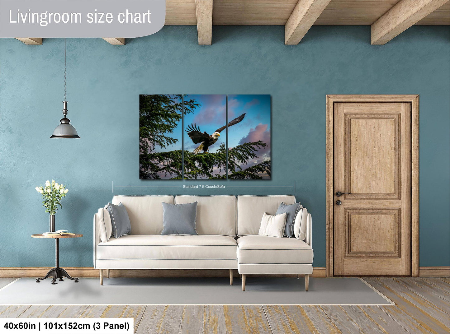 a living room with a large white sofa, a wooden door, and a painting of a bird in flight hanging on the wall.