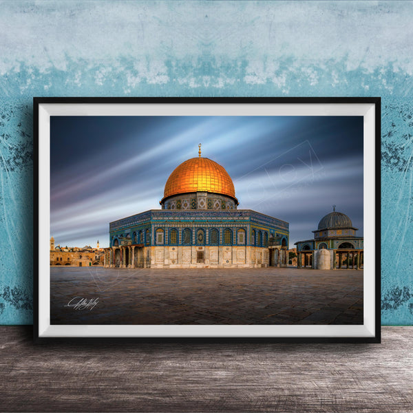 a large, ornate building with a golden dome, possibly a mosque or a significant historical structure, set against a blue sky with wispy clouds.