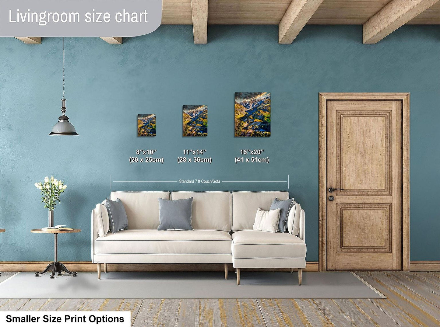 a living room with a white sofa, a wooden door, and a hanging light fixture. There are three framed artworks displayed on the wall, each with a different size and frame. The living room appears to be well-decorated and spacious.