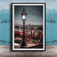 a cityscape with a tall street lamp in the foreground, overlooking the city.
