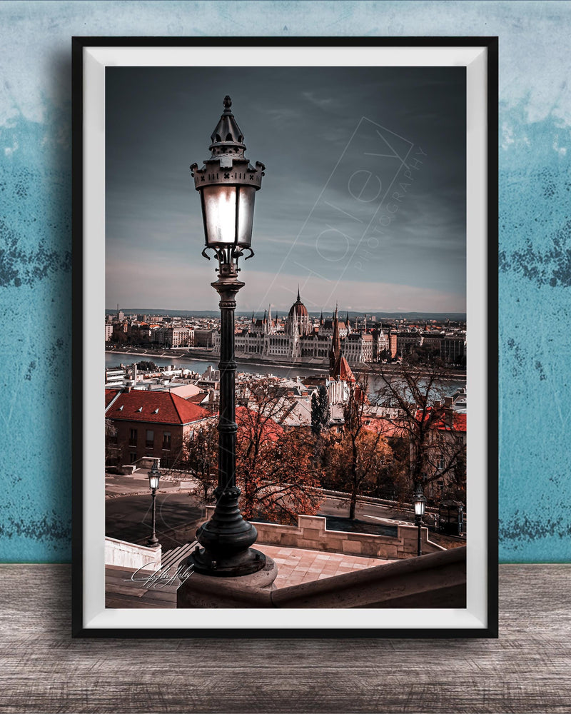 a cityscape with a tall street lamp in the foreground, overlooking the city.