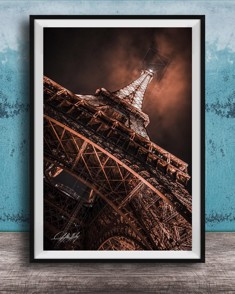a close-up view of the Eiffel Tower, showcasing its intricate metal lattice structure and the surrounding night sky.