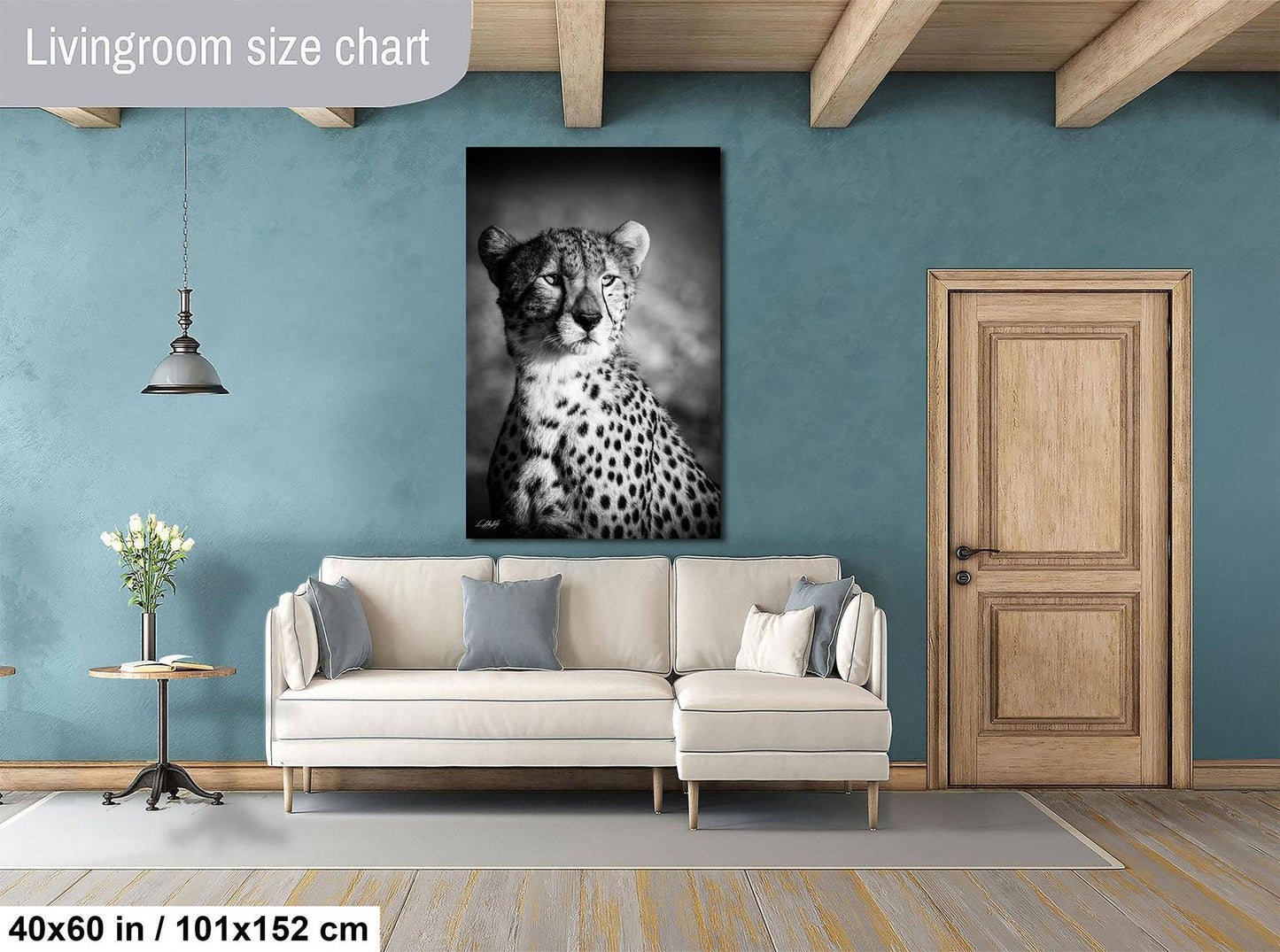 a living room with a large black and white photograph of a cheetah on the wall, a white sofa, and a wooden door.